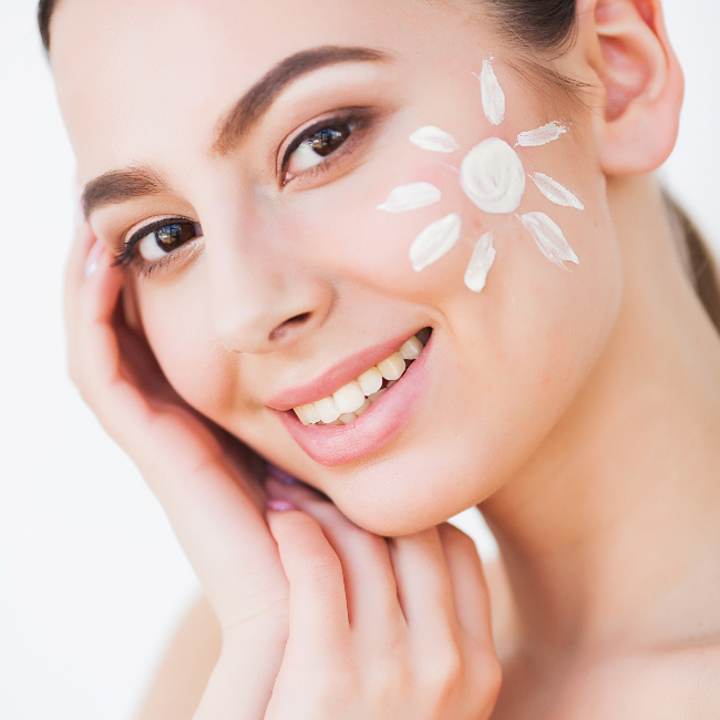 Woman with sunscreen applied on her face against a white background